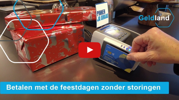 foto van een pinautomaat met op de achtergrond een paar ingepakte cadeaus